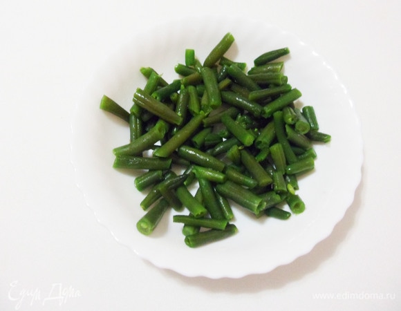 Стручковую фасоль варить в подсоленном кипятке 3 минуты. Затем откинуть на сито, обдать холодной водой для сохранения цвета и упругости фасоли.