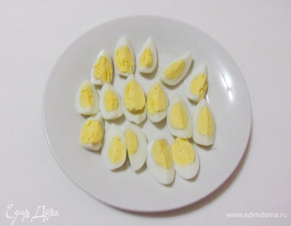 Перепелиные яйца варить в течение 4 минут, охладить, освободить от скорлупы и нарезать четвертинками.