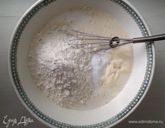 Порциями добавить просеянную муку и соду, замесить тесто.