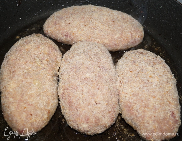 Раскалите сковороду с маслом. Обваляйте зразы в сухарях, выложите их на сковородку местом соединения фарша вниз.