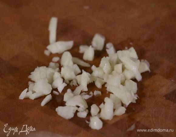 Два зубчика чеснока почистить, раздавить плоской стороной ножа и мелко порубить.