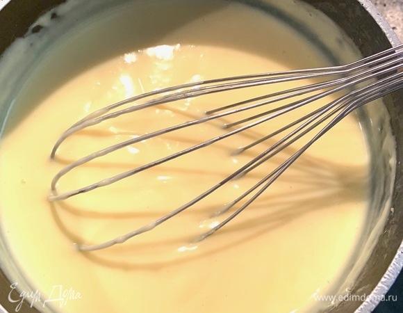 В сотейник наливаю 400 мл молока, добавляю сахар, довожу до кипения. Пока молоко нагревается, в миску наливаю оставшиеся 100 мл молока, добавляю крахмал, перемешиваю таким образом, чтобы не было комков. Затем добавляю желтки, ванильный сироп, хорошо взбиваю. Вливаю яичную смесь в закипевшее молоко очень тонкой струйкой, быстро помешивая. Не прекращая помешивать, варю 2 минуты.