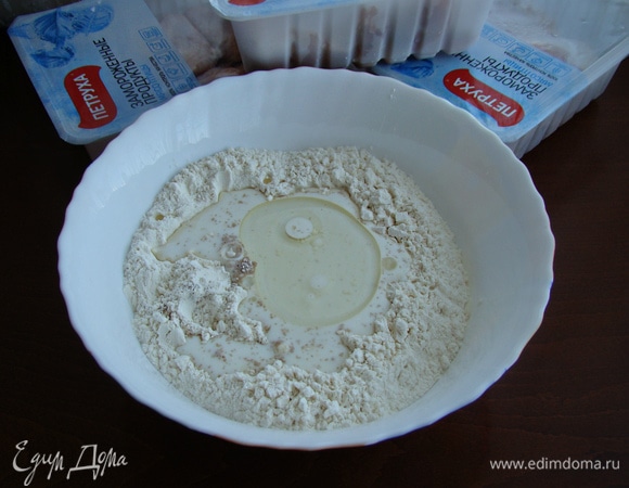 В миску просеять муку. Сделать лунку и влить теплое молоко, воду и половину нормы растительного масла. Всыпать сухие дрожжи, соль, сахар.