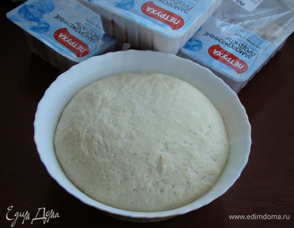 К этому времени наше тесто подошло. Его необходимо обмять и разделить на две части. Каждую часть тонко раскатать в прямоугольник и смазать оставшейся частью растительного масла. Свернуть в рулет.