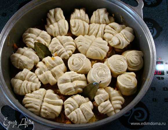 Штрудли аккуратно уложить в казан поверх курицы, капусты и картофеля. Только не совсем плотно, так как тесто в процессе приготовления увеличится. Добавить 2 лавровых листа и накрыть плотно крышкой. Как только содержимое закипит, убавить огонь и тушить на медленном огне минут 30. После этого казан снять с огня и, не открывая крышки, дать блюду постоять минут 5.