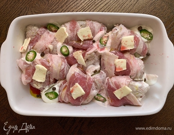 Разогреваю духовку до 190°C. Добавляю к цыплятам душистый перец, сливочное масло, лавровый лист, перец чили. В оригинальном рецепте последнего ингредиента нет, но мне нравится сливочно-острый соус. Вы можете его не класть.