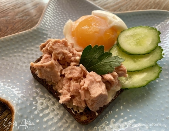 Сверху кладу очищенное яйцо, тунец и дольки огурца.