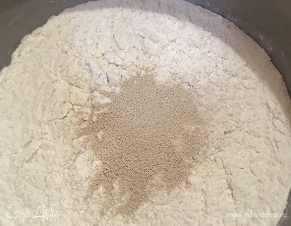 Муку просеять, поместить в миску. Всыпать туда же дрожжи и перемешать.