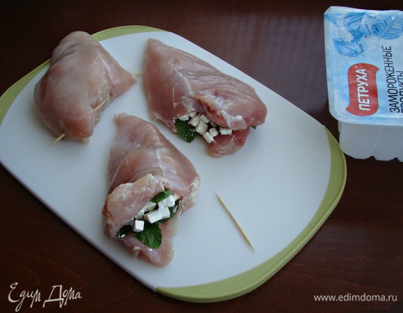 Куриное филе ТМ «Петруха» просушить бумажным полотенцем и в широкой его части сделать глубокий надрез в виде кармашка. Наполнить карман сыром и листьями мяты, а срез закрепить шпажкой.