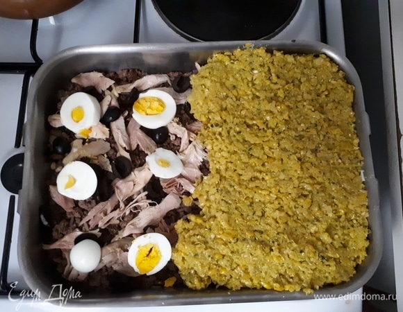 На дно глубокого противня уложите пино, затем сверху выложите куриное мясо, нарезанные яйца и оливки. Укройте кукурузным пюре. Посыпьте сверху сахаром. Поставьте блюдо в духовку на 30 минут при 180°C.