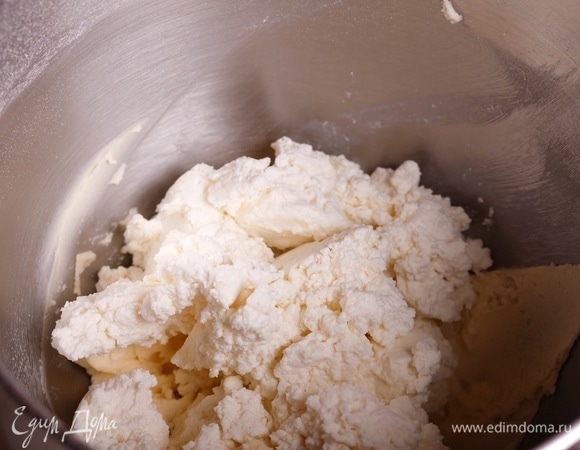 Перетереть творог через сито и добавить в чашу к сливочному крему.