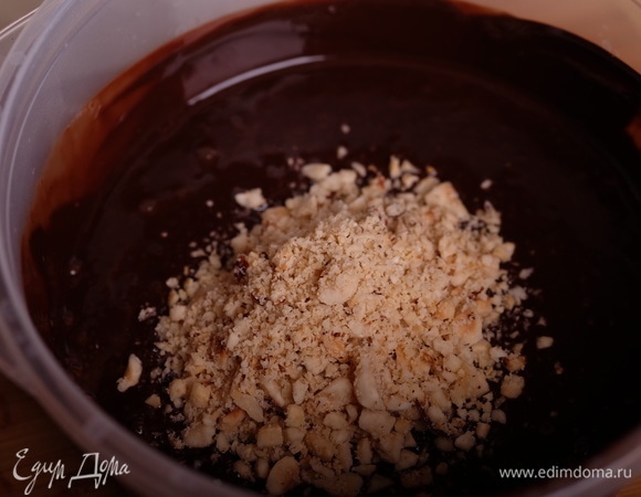 Шоколад растопить в микроволновой печи короткими импульсами по 15 сек., добавить в растопленный шоколад кукурузное масло и взбить погружным блендером. Добавить нарубленные орехи.