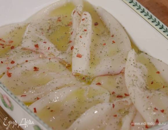 Тушки кальмаров выложить в жаропрочную керамическую форму, полить оливковым маслом, посыпать орегано, чили и лимонной цедрой, сбрызнуть лимонным соком.