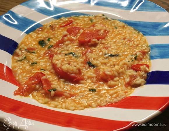 Когда жидкость выпарится, добавить в рис оставшееся сливочное масло, натертый сыр и сделать монтекатуру, то есть большой ложкой перемешать ризотто движениями снизу вверх, слегка подбрасывая. Затем добавить помидоры с базиликом и чили и все перемешать. Выключить огонь и дать настояться несколько минут.