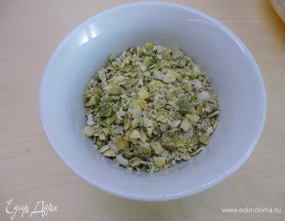 Измельчаем тыквенные семечки, прокатывая их скалкой.