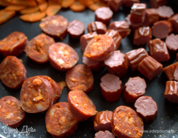 Нарезать колбаски и высыпать в сковороду для тушения.