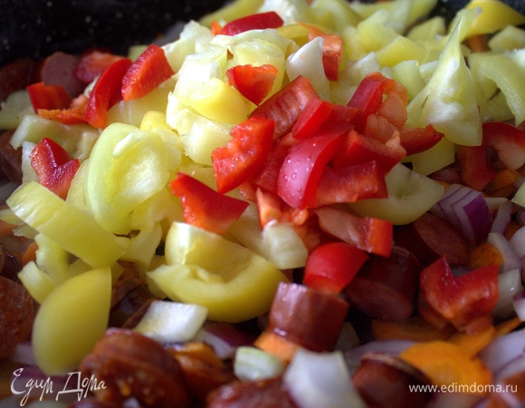 Чуть позже высыпать в сковороду кусочки перцев.
