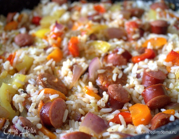 Распределяем рис по всей сковороде, добавляем 1–2 стакана воды и оставляем рагу тушиться под крышкой.