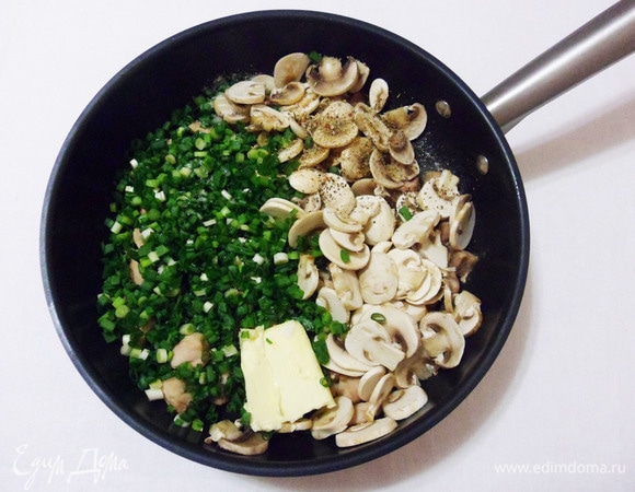 Всыпать в сковороду шампиньоны и зеленый лук. Добавить сливочное масло, соль, черный перец и тимьян. Все аккуратно перемешать, готовить на среднем огне еще 5 минут.
