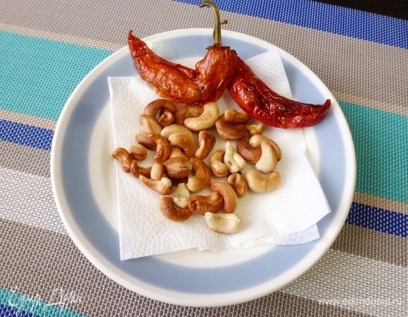 Выложить кешью и перчики на салфетку.