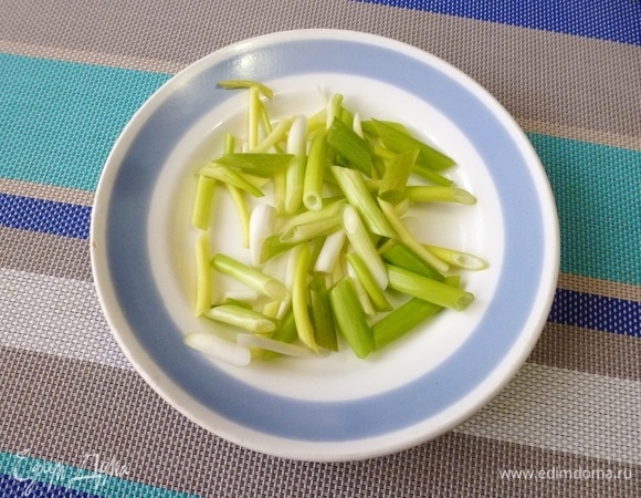 Зеленый лук нарезать наискосок длиной 2–3 см.