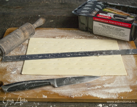 Обычно в упаковке слоеного теста 4 листа. Берем два листа, немного раскатываем. Делаем сквозные надзрезы длиной 1.5 см в шахматном порядке. Надрезанное тесто немного растягиваем.