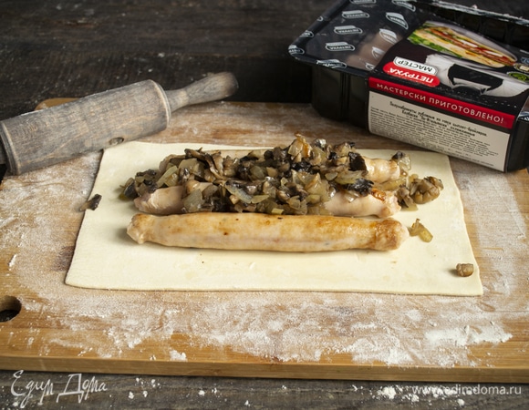 На колбаски выкладываем половину лука с грибами.