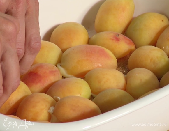 Добавить в форму сливочное масло. Абрикосы разделить пополам, извлечь косточки, выложить в форму для запекания, покрыть ими все дно.