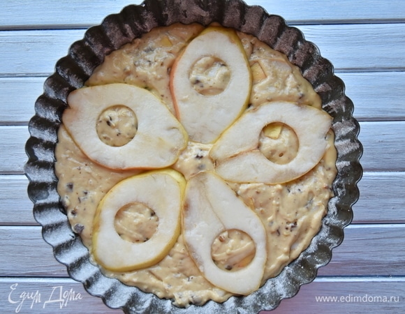 Подготовить форму для выпечки (диаметр — 24 см). Смазать ее растительным маслом и присыпать небольшим количеством муки. Выложить тесто. Распределить ломтики груши поверх теста.