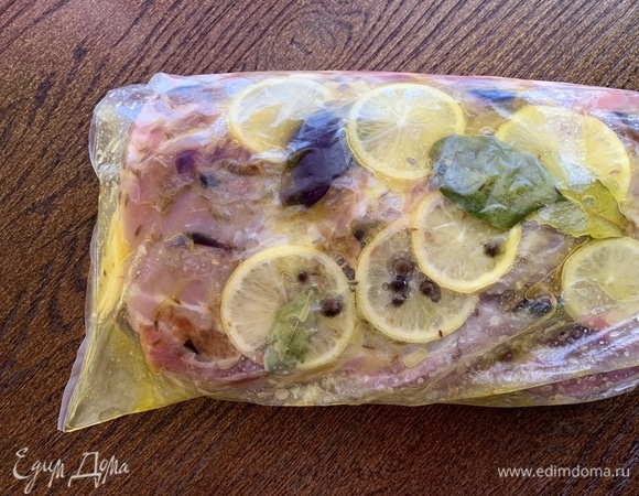 Мариную свинину. Очищенный чеснок нарезать, добавить соль, нашпиговать свинину. Сверху посыпать тмином и 1 ст. л. сахара. Нарезать лимон, обложить мясо дольками, положить сверху лавровый лист и перец горошком, полить оливковым маслом (2 ст. л.). Кладу в пакет для маринования и убираю в холодильник на 2 часа.