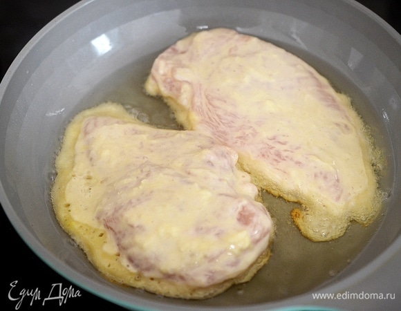 В сковороде разогрейте масло. Обжарьте шницели в кляре на небольшом огне сначала с одной стороны минут 7.