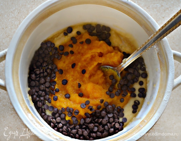 В конце добавьте тыквенное пюре и вмешайте в тесто. Если тесто получилось слишком густое, добавьте пару ст. л. кипяченой воды. Добавьте капли шоколада и аккуратно перемешайте.