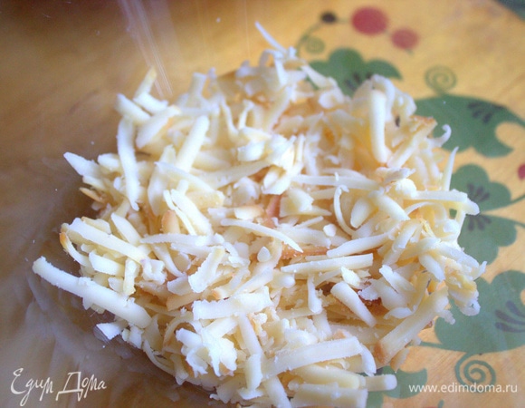 Часть сыра насыпать на дно салатника.