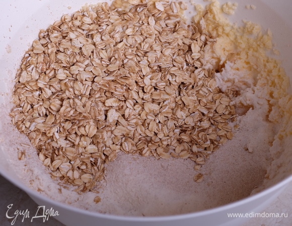 Соединить в другой миске оба вида муки, соду, корицу и соль, просеять в яичную смесь. Добавить овсяные хлопья. Все хорошо перемешать.