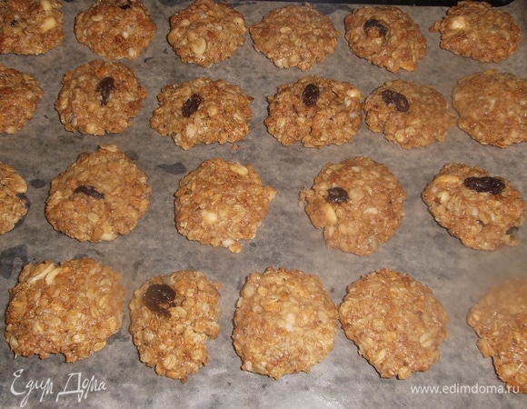 Шарики из теста слегка приплюснуть руками. Выложить на противень, застеленный пекарской бумагой и смазанный растительным маслом.