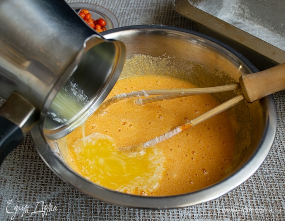 Сливочное масло растапливаем в сотейнике, остужаем. Добавляем растопленное масло в тесто, хорошо перемешиваем.