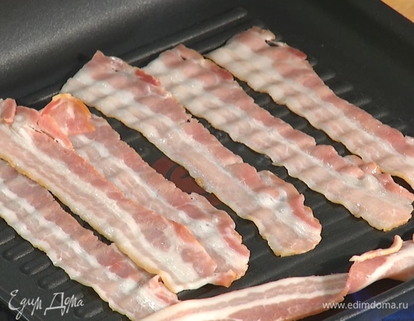 Разогреть сковороду-гриль, выложить на нее полоски бекона, полить бекон маслом. Обжарить с обеих сторон. 