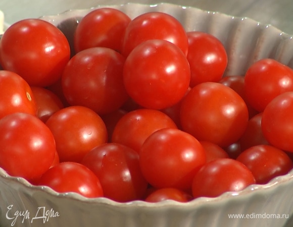 Помидоры разрезать пополам, добавить к чесноку и специям.