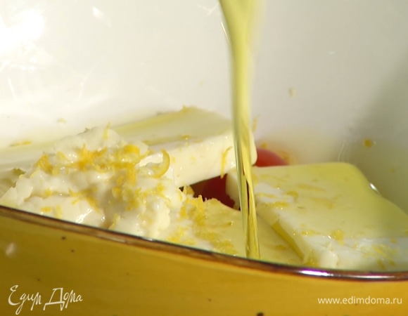 Овечий сыр нарезать толстыми пластинами, добавить в миску к помидорам. Туда же натереть цедру лимона, добавить оливковое масло, все перемешать.