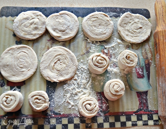 Каждую стопку из трех полосок (всего получилось 12 стопок) разверните на бок и сверните в спираль. На припыленной мукой поверхности раскатайте каждую спираль в лепешку диаметром 7,5 см. Следите, чтобы витки спирали не расходились. Если такое случится, соедините витки и еще раз пройдитесь скалкой. В результате таких действий нарушается слоистая структура, тесто при выпечке не будет стремительно подниматься вверх и выталкивать жидкую начинку.