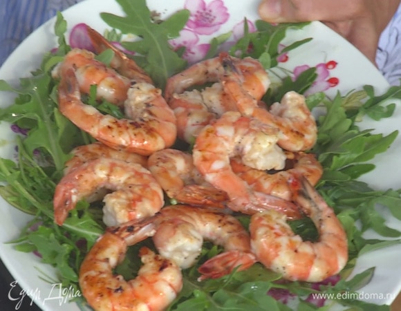 Сверху на руколу выложить обжаренные креветки.