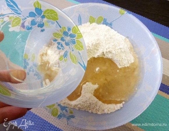 Смешать все сыпучие ингредиенты в одной миске. Смешать воду с растительным маслом. Добавить в муку воду с маслом. Не вливайте все сразу, возможно, жидкая смесь останется.