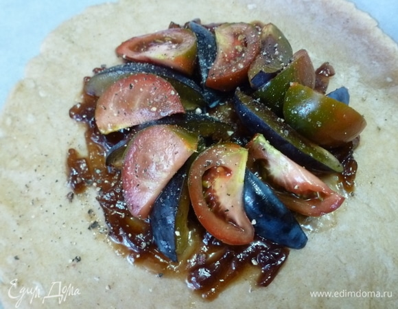 На луковый джем выложить поочередно дольки сливы и помидоров. Поперчить. Завернуть края теста к середине. Сбрызнуть галету оливковым маслом. Духовку разогреть до 190°C и выпекать галету 35–45 минут.