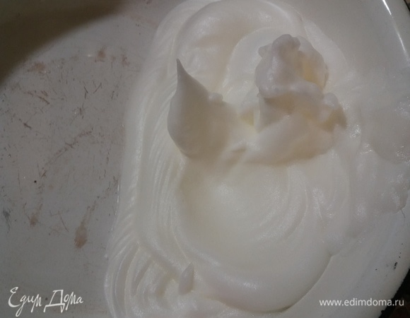 В отдельной миске взбить яичные белки до жестких пиков.