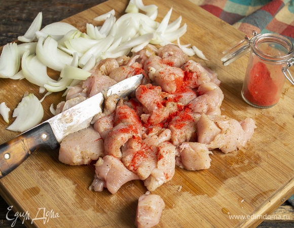 Мясо посыпаем молотой паприкой, перчим, солить не нужно. Репчатый лук нарезаем произвольно, я обычно режу крупными перьями.