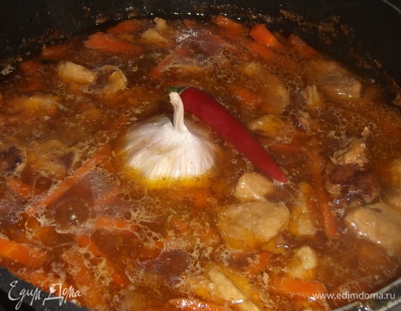 Убавить огонь до минимума. Томить зирвак 40 минут. Через 30 минут добавить в зирвак соль, чеснок (головку целиком) и острый перец (стручок).