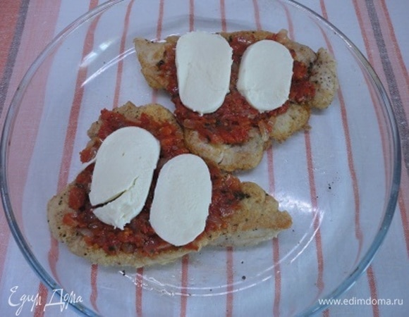 В форму для запекания выложить шницели, сверху соус и кусочки моцареллы. Запекать в духовке 15 минут при температуре 200°C.