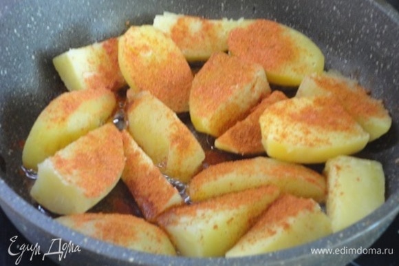 Отваренный картофель нарезать крупными кусочками, выложить на сковороду с разогретым растительным маслом, посыпать паприкой, сладкой и острой, перемешать и слегка поджарить.