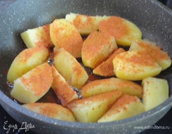Отваренный картофель нарезать крупными кусочками, выложить на сковороду с разогретым растительным маслом, посыпать паприкой, сладкой и острой, перемешать и слегка поджарить.
