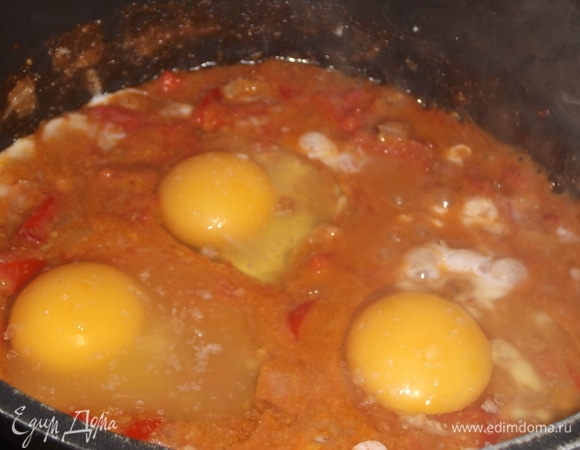 В орехово-томатной смеси сделать углубления. Влить яйца. Посолить. Накрыть крышкой. Тушить до полного схватывания белка. Желток должен оставаться жидким.